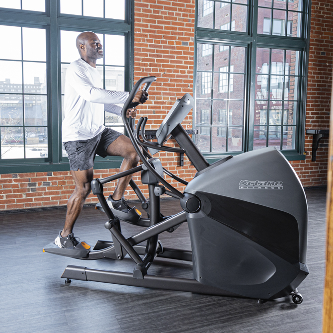 Man working out on the XT-One standing elliptical - side view