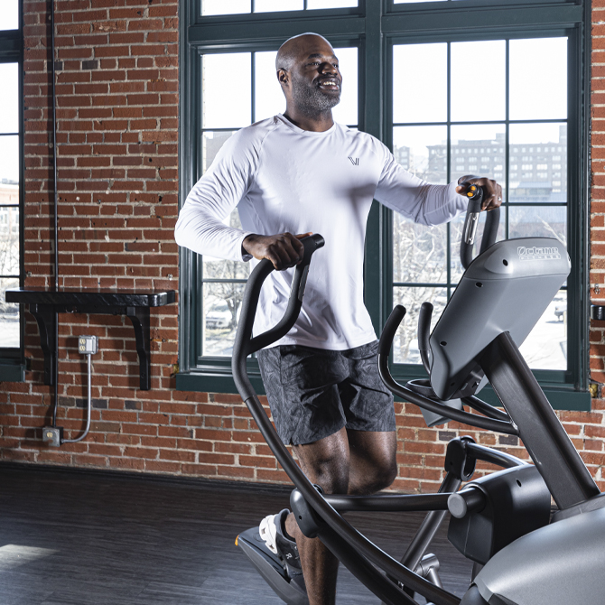 Man working out on the XT-One standing elliptical - upper body focus